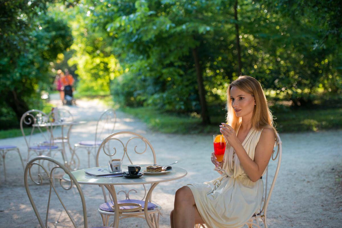Na siki je dekle, ki v Ljubljani na terasi pije sok